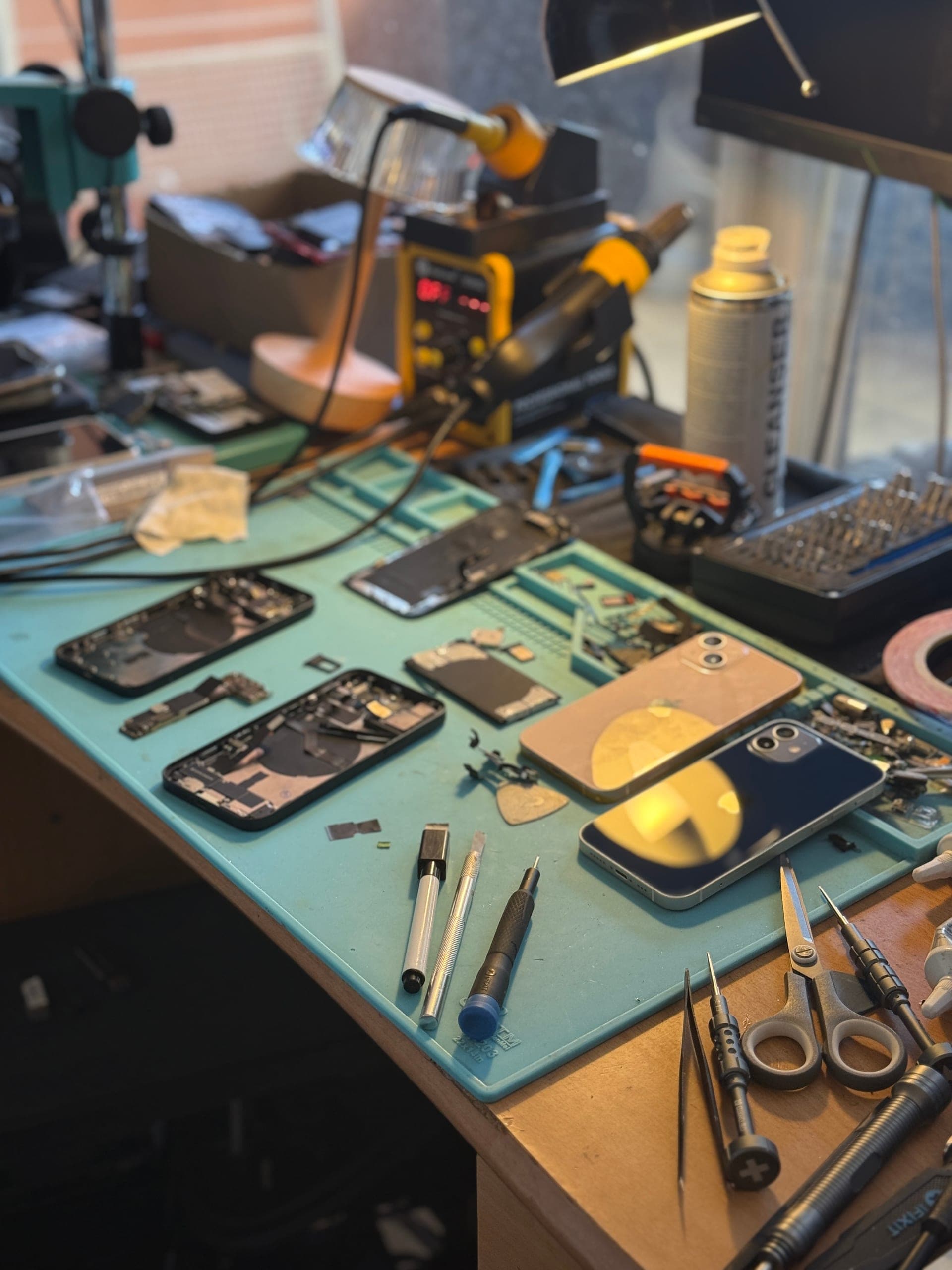L'Atelier de Sam repair bench in Poitiers — disassembled smartphones, soldering station and precision tools, certified QualiRépar craftsman